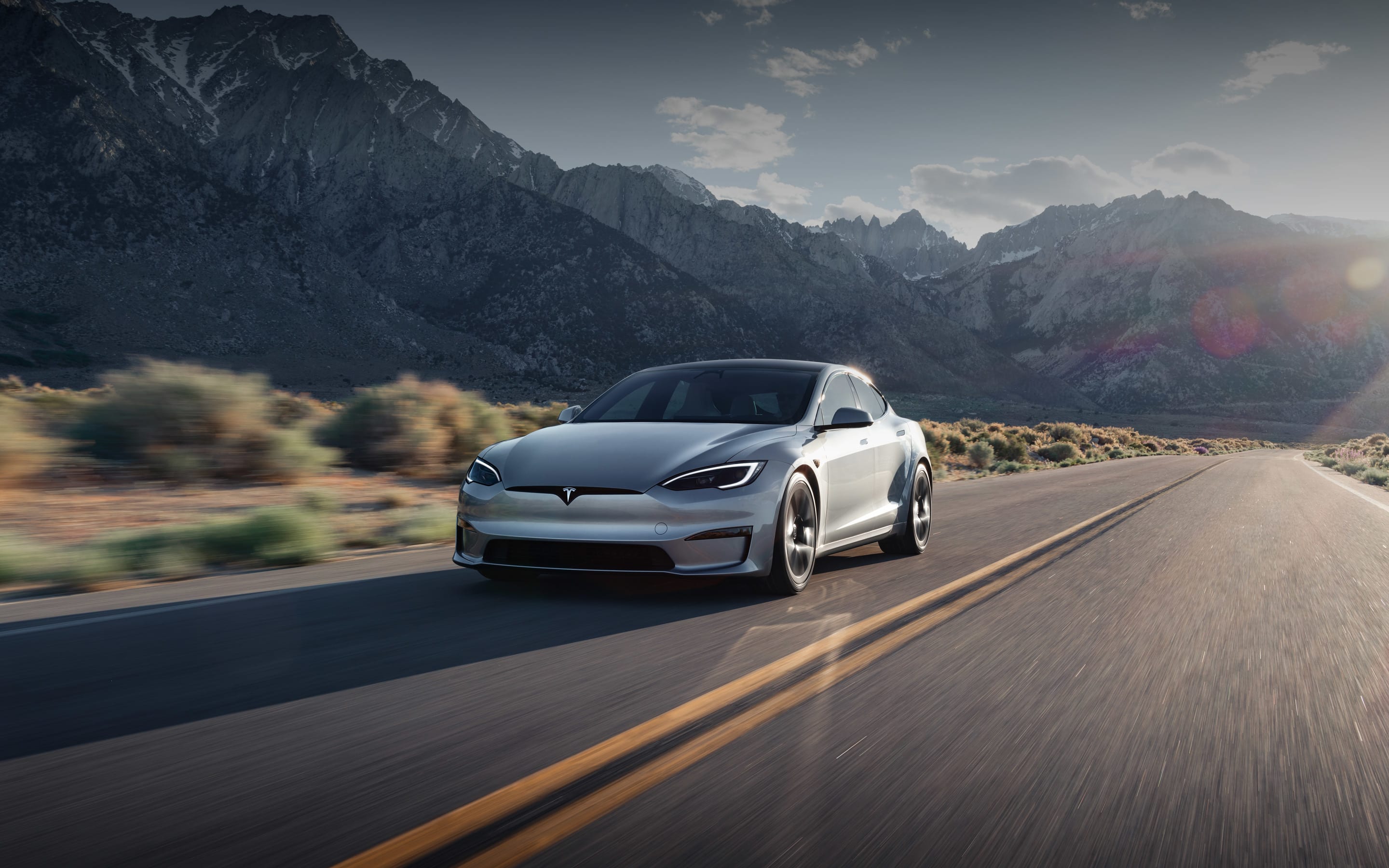 Solid black Model S accelerating on an elevated highway	